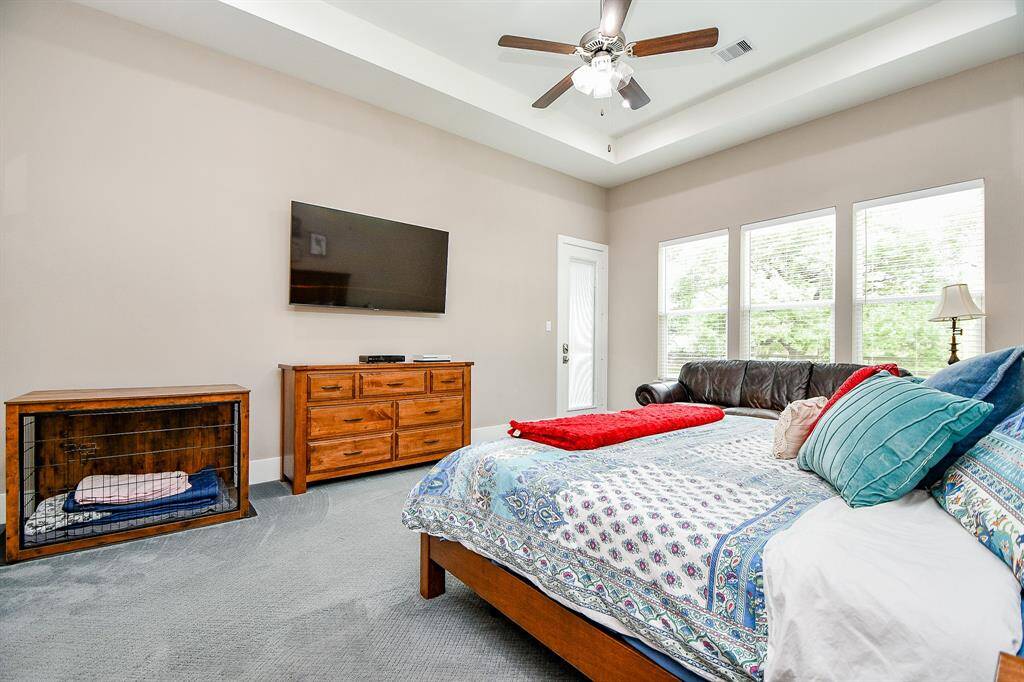 This angle highlights the tray ceiling detail and natural light in the primary bedroom. A private door leads directly to the backyard patio, perfect for morning coffee or evening unwinding.
