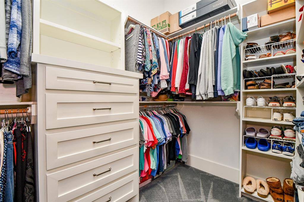 This is one of the two spacious walk-in closets in the Primary Bedroom.  It features built-in drawers, ample hanging space, and organized shelving for shoes and accessories.
