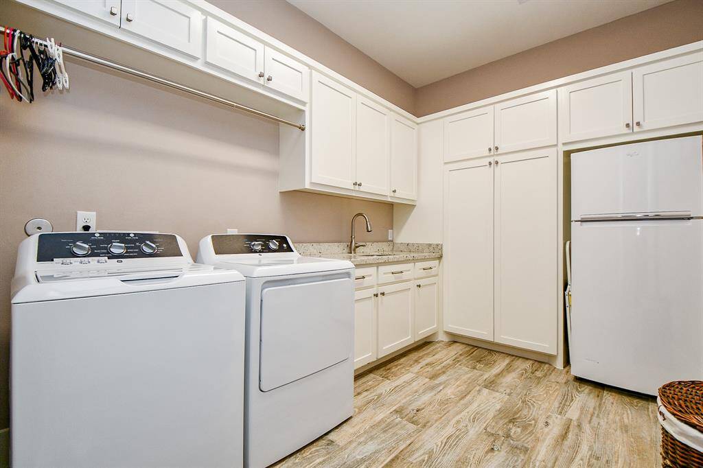 This huge utility room blends function and style with abundant cabinetry, a deep sink, and a handy built-in hanging rod. Laundry day just got an upgrade—almost enough to make it fun! (Washer, dryer, and refrigerator not included).