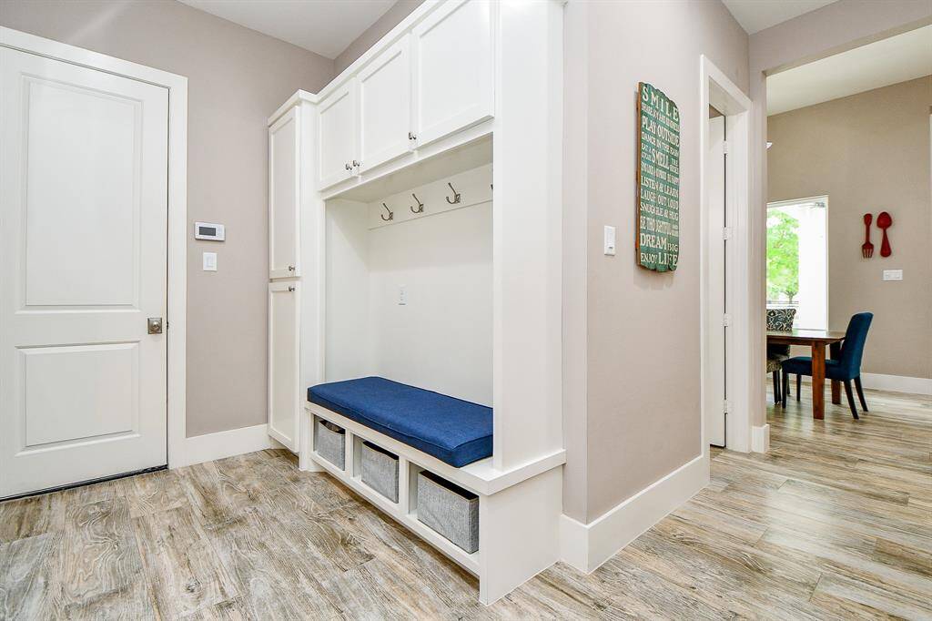 This custom built-in drop zone features a cushioned bench, coat hooks, and open cubbies for easy storage. Perfectly placed off the hallway as you enter from the garage.  It keeps everyday essentials organized and out of sight.
