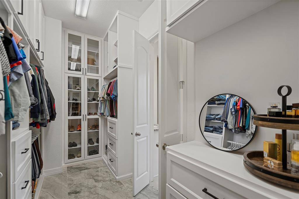 Primary Closet with custom built shelving and cabinets.