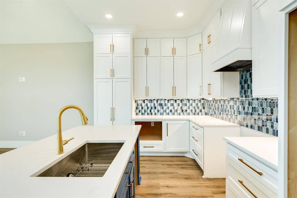 Elegant blue tile backsplash adds a modern and stylish touch to the kitchen.