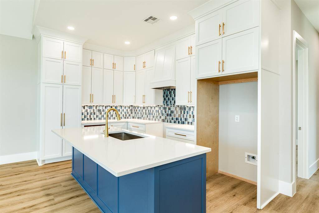 Expansive storage with elegant floor-to-ceiling cabinets with brass hardware.
