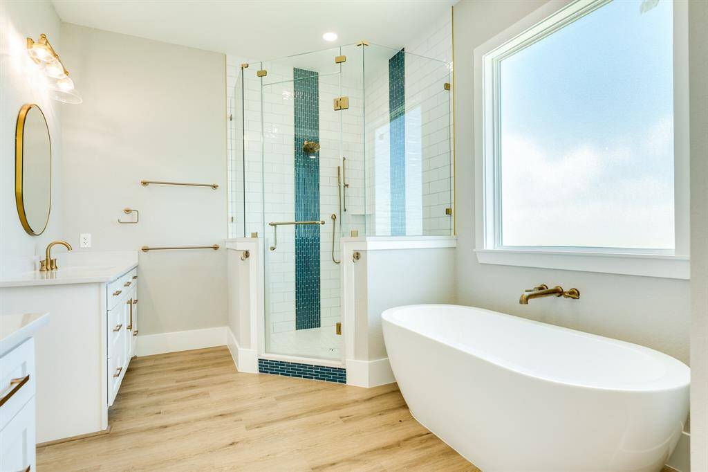 Luxurious soaking tub and elegant walk-in shower all showered with natural light.