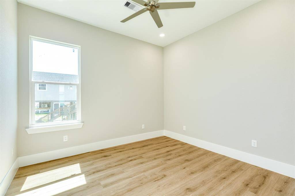 Elegant vinyl plank flooring throughout the home with a window, tall ceilings, and recessed lighting in Bedroom 1.