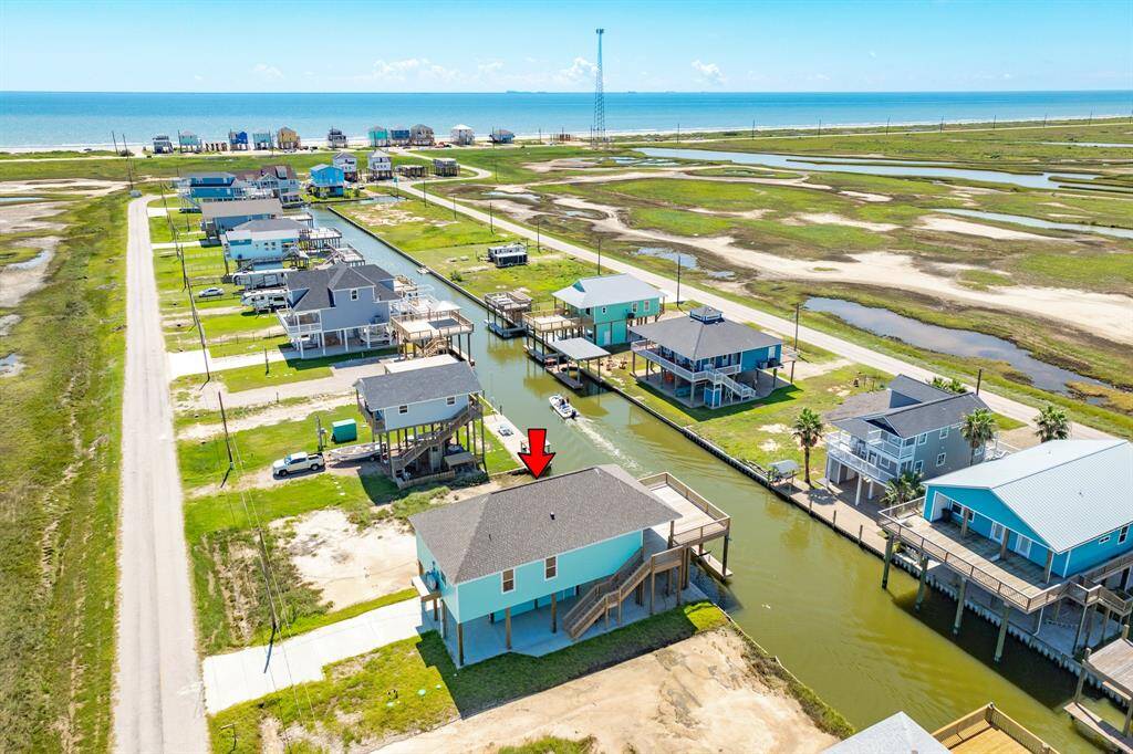 This coastal home is situated on a canal with direct water access and is a short distance from the beach. Elevated, it offers scenic views and a spacious deck. The neighborhood features similar canalfront properties, providing a serene and picturesque setting.