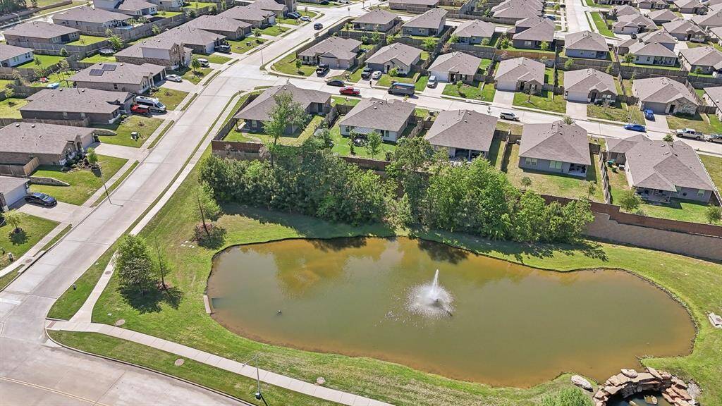 6112 Pear Pass Court is the second home from the left behind this pond.