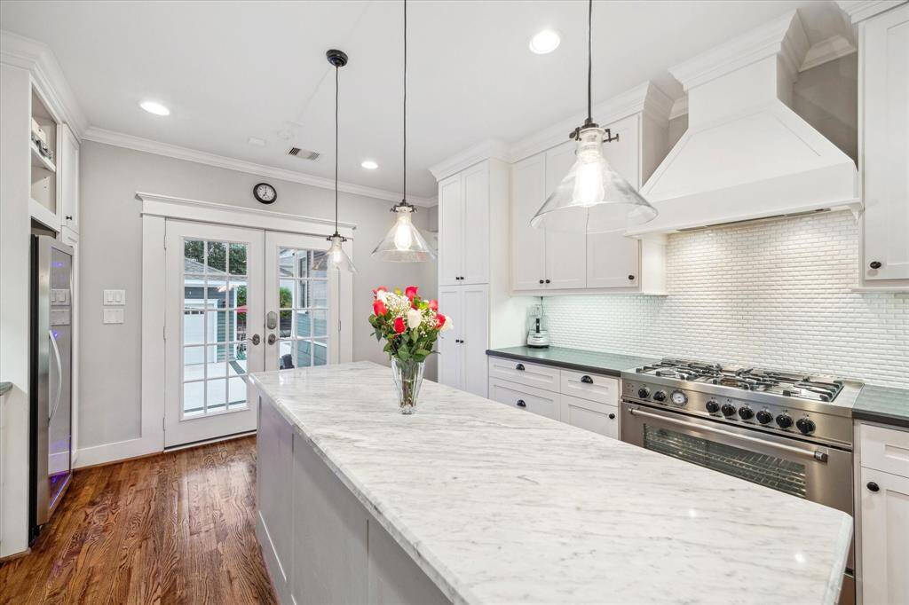 The chef of the house can whip up the favorite family meals with this 36in Bertazzoni gas range.  A large island without a cooktop or sink is hard to find. This one provides excellent serving or prep space. French doors lead to the backyard and garage.