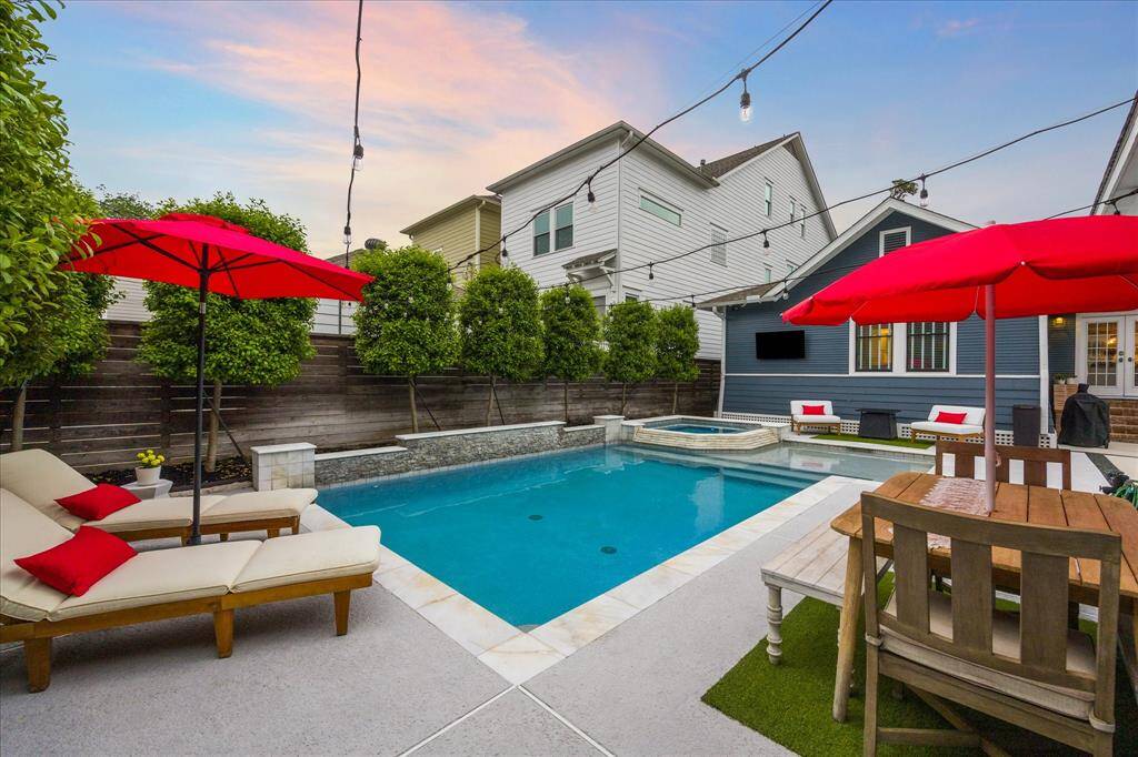 From this angle you can see the side wall of the pool which features a waterfall, the overhead bistro lights, and the wall-mounted television on the back of the home.  A truly fantastic entertaining space.