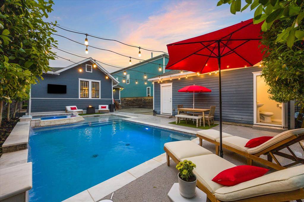 Smartly designed, there are several entertaining spaces around the pool.  Bistro lights hang from the garage to the fence creating an inviting ambiance for evening events.  Notice the pool bath on the right of the picture.  No more running in and out of the house.