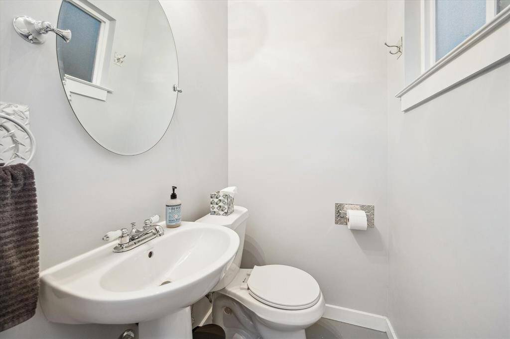 The pool bath is thoughtfully designed with a pedestal sink, ceiling fan, an operable window, and stylish mirror.