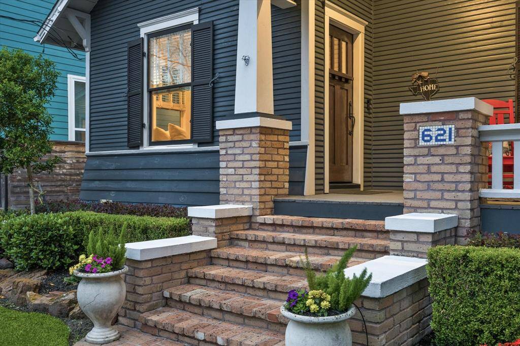 A beautiful brick stairway leads to the covered front porch and front door. Notice the inlayed blue tile address added on the right column which pays homage to the early days of The Heights.