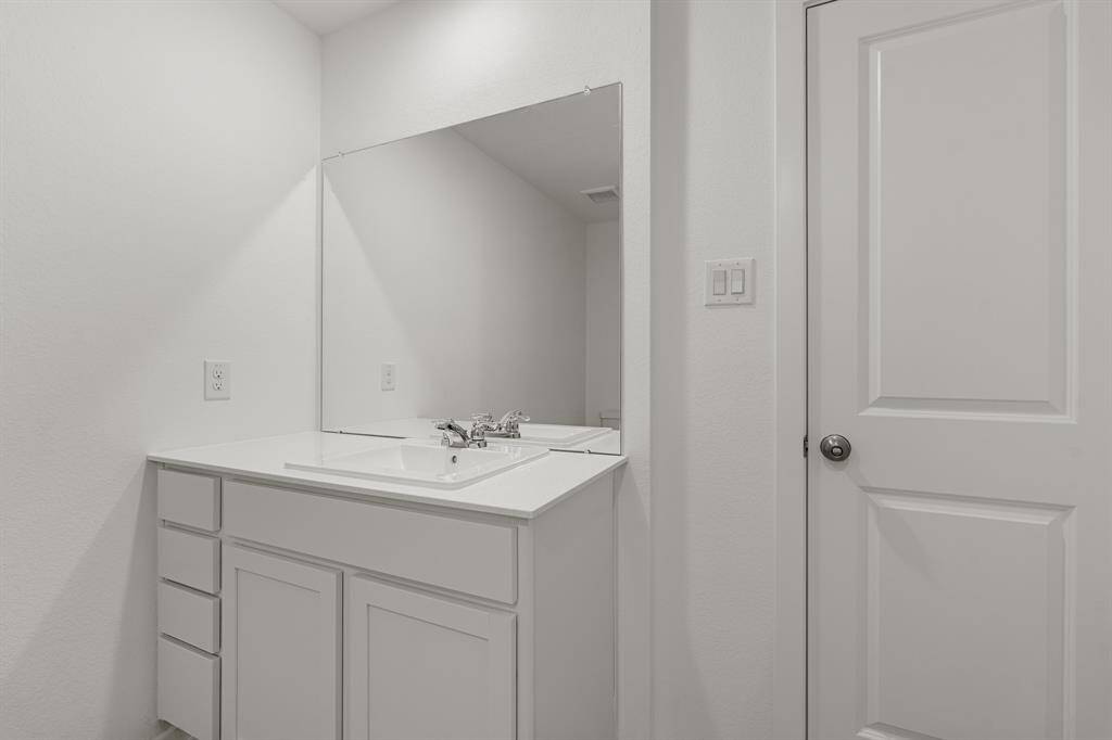 The bathroom is complete with white cabinetry, and quartz countertops.