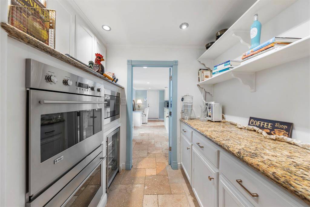 Just off the kitchen, you'll find an open butler's pantry featuring double ovens, a microwave, a beverage fridge, and additional countertop and cabinet space for all your storage and entertaining needs.