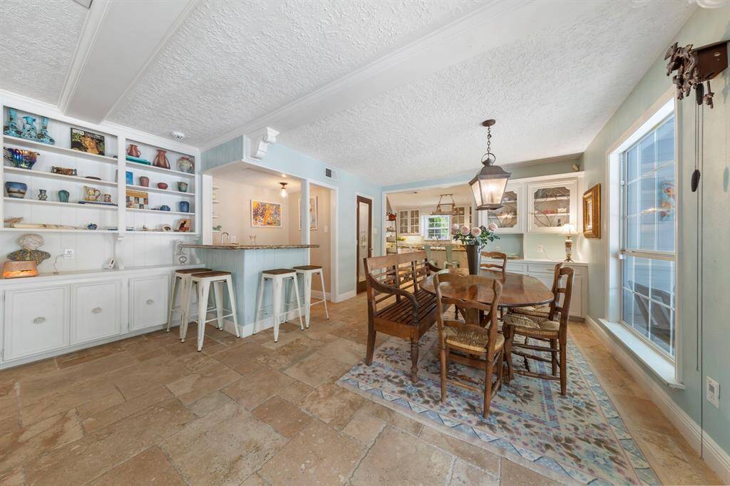 Across from the breakfast nook, you'll find a stylish wet bar complete with built-in shelving, perfect for entertaining guests.