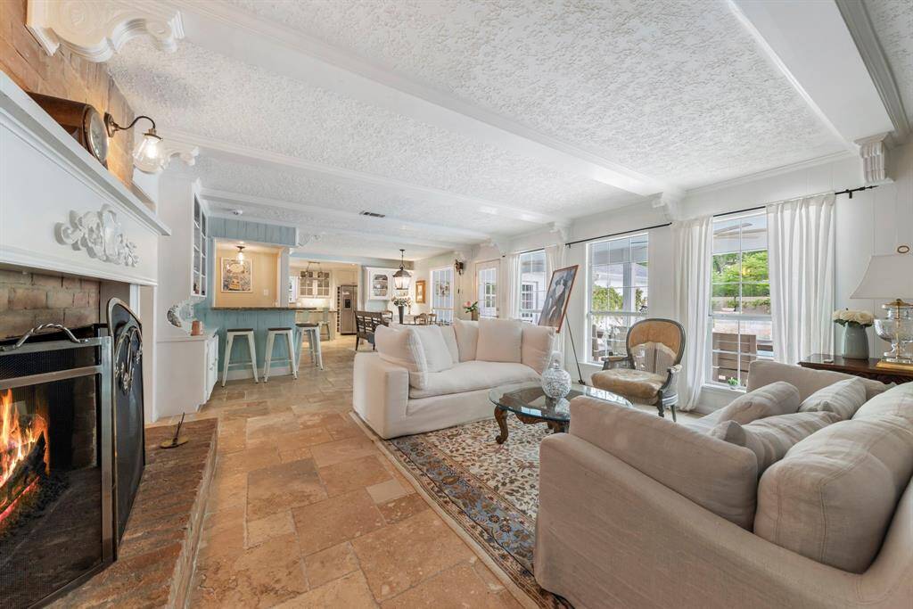 Spacious open family room, ideal for entertaining and family gatherings, featuring custom millwork and an abundance of windows that offer stunning views of the beautiful backyard.