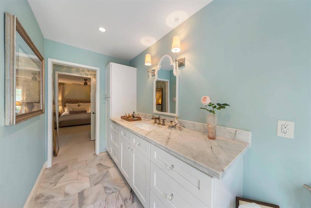 Updated spa-like primary bathroom featuring custom cabinetry, offering both style and functionality.