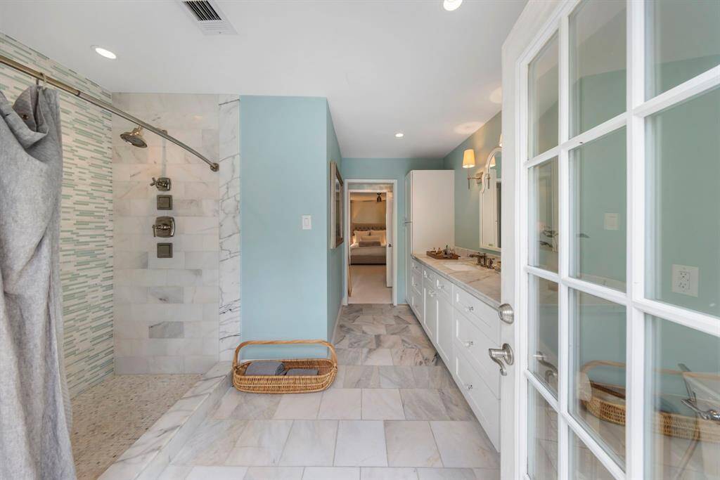 Featuring a stylish tile walk-in shower and private access to the back patio, this bathroom offers the perfect blend of luxury and convenience.