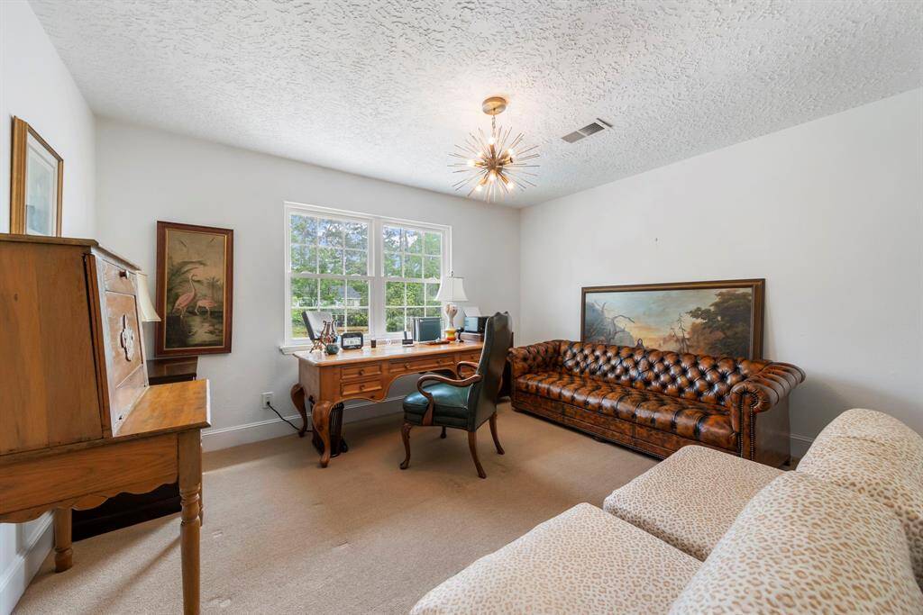 One of four spacious upstairs bedrooms, featuring fresh carpet, new paint, updated baseboards, a closet, and plenty of natural light from the windows.