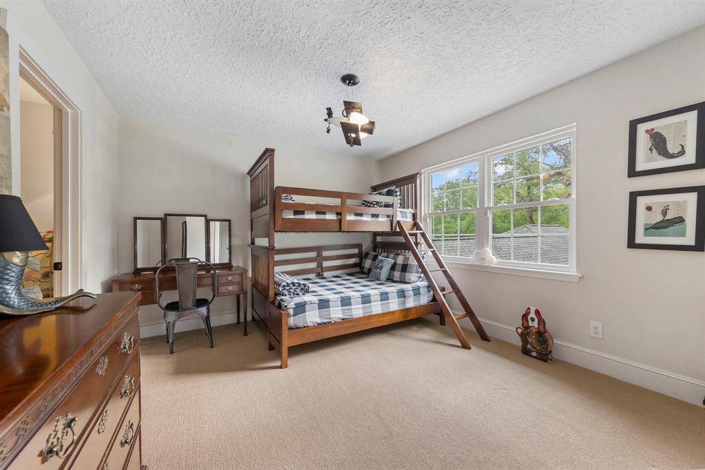 The fourth upstairs bedroom offers fresh carpet, new paint, updated baseboards, a closet, windows that flood the room with natural light, and a private en-suite bathroom.