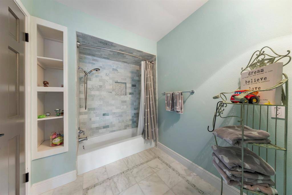 Step into the updated en-suite bathroom, featuring a tile shower/tub combo and a separate vanity area for added convenience and privacy.