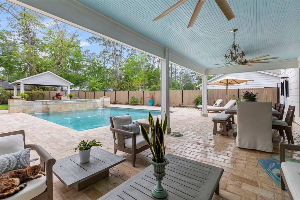 Welcome to the breathtaking backyard! A massive covered patio offers the perfect spot to relax while overlooking the sparkling, modern pool.