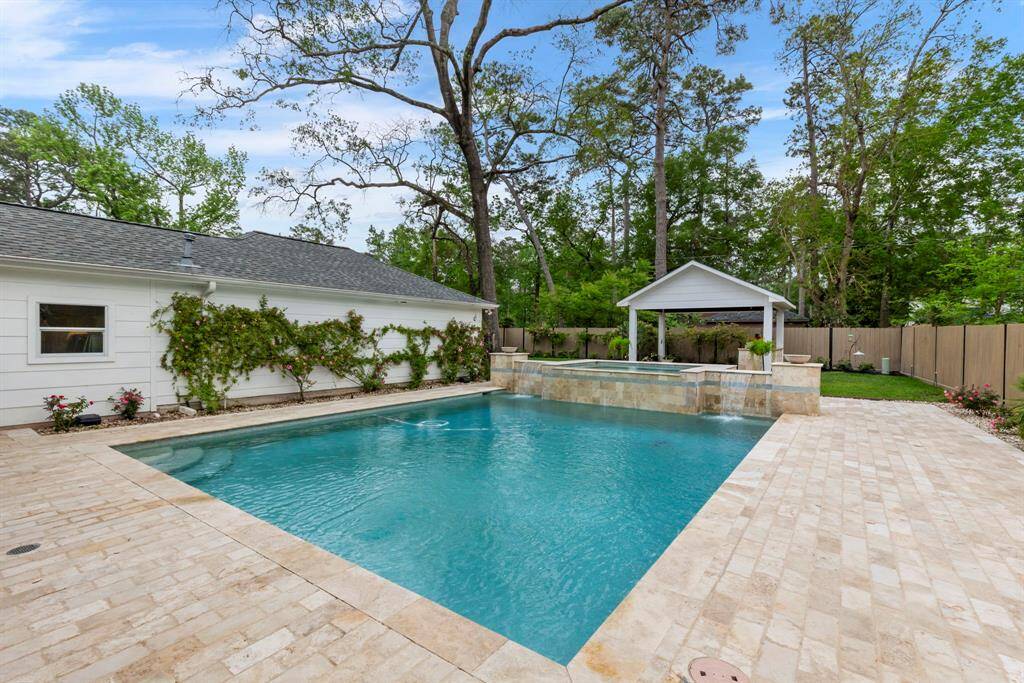 Enjoy a large pool with an attached spa and water features, complemented by expansive decking and lush landscaping that creates a serene oasis.