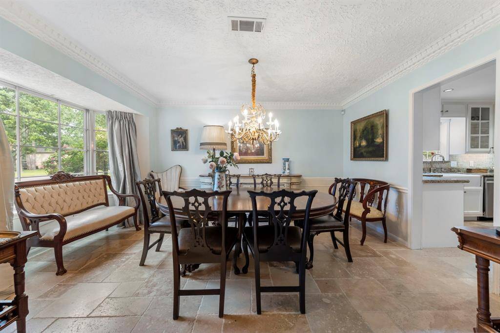The formal living room flows seamlessly into the elegant dining room, featuring a charming bay window and classic chair rail molding—perfect for hosting gatherings.