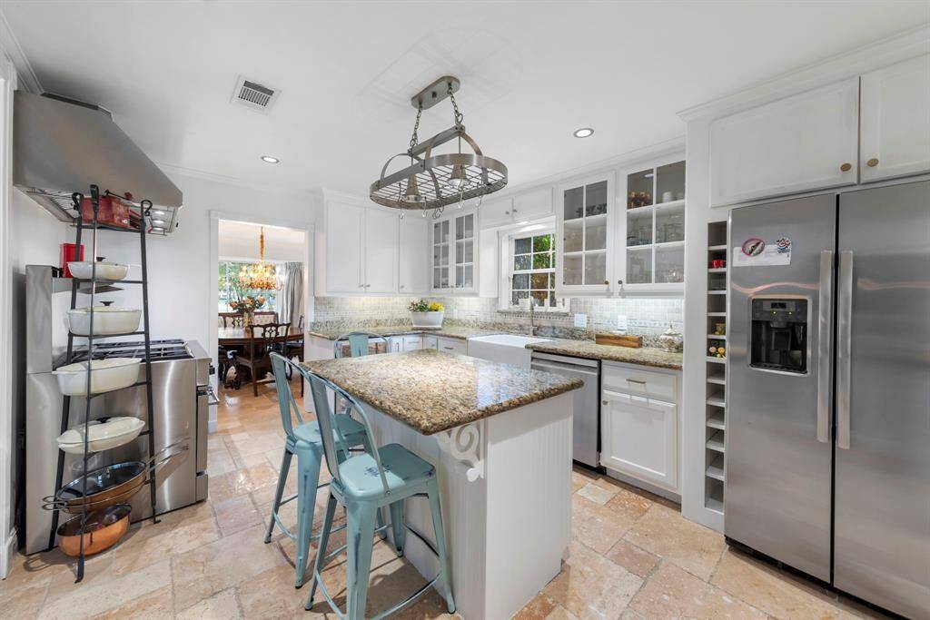 Step into the chef’s dream kitchen, showcasing sleek granite countertops, crisp white cabinetry with modern hardware, and a central island ideal for casual dining and meal prep.