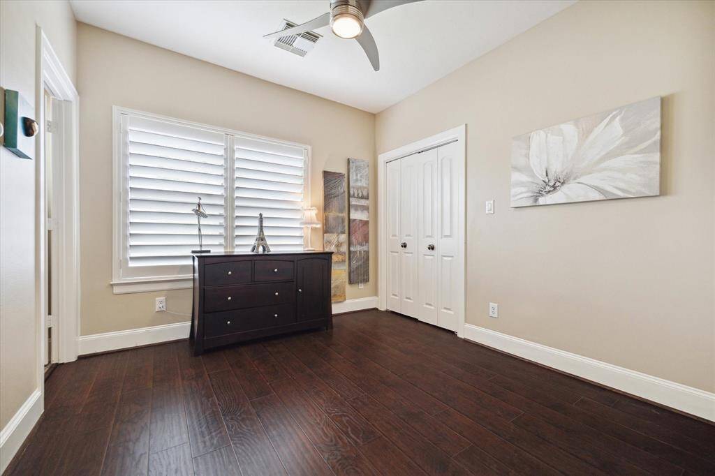 Secondary Bedroom complete with wood floors, plantation shutters and a ceiling fan