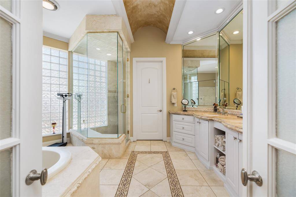 The primary bathroom provides ultimate luxury. With a glass-enclosed shower, soaking tub, and dual sinks set in elegant marble countertops, every detail has been thoughtfully designed to create a serene, spa-like retreat. Elegant finishes and sophisticated touches elevate the space, offering an unparalleled experience in relaxation and style.