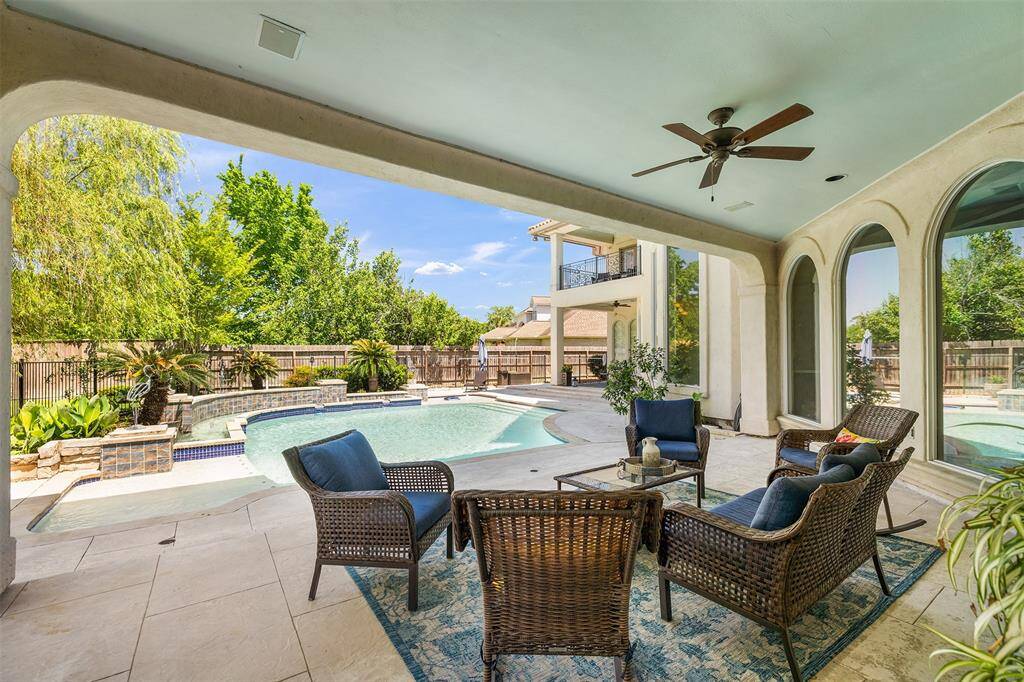 Soak in views of the sparkling pool from the covered patio. The lush greenery provides additional privacy. This space is perfectly poised for relaxing and entertaining!