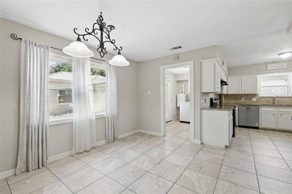 Check out this spacious breakfast area, featuring elegant tile flooring and setting the tone for the home's open, connected layout.With its seamless flow into the formal family room, you can enjoy meals while still staying connected with loved ones nearby.
