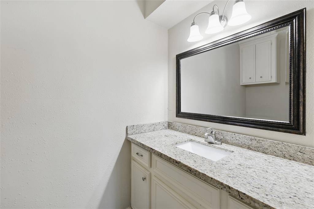 A convenient half bath is located downstairs, just off the breakfast area and kitchen, offering easy access for both family and guests.