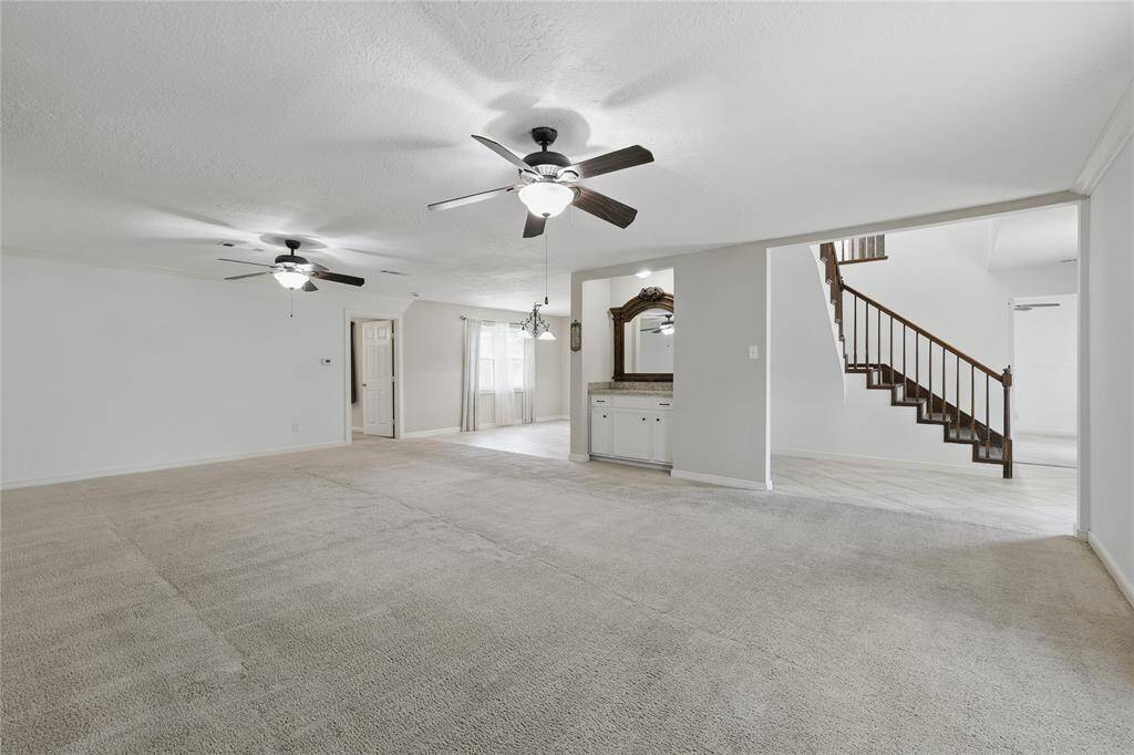 Enjoy entertaining in this spacious family room, complete with crown molding, a cozy fireplace, and a stylish bar area.