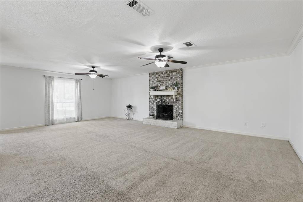 Enjoy entertaining in this spacious family room, complete with crown molding, a cozy fireplace, and a stylish bar area.
