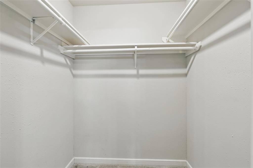 The downstairs bedroom includes a generously sized walk-in closet, providing ample storage and easy accessibility.