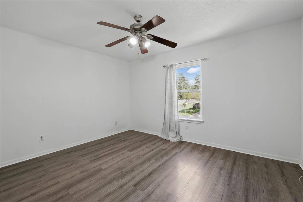Welcome to this bright and inviting secondary bedroom, featuring sleek LVP flooring and ample closet space—perfect for all your storage needs.