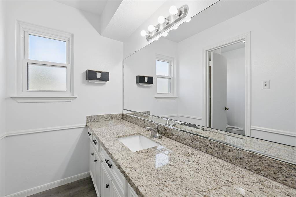 This full bath upstairs features beautiful granite countertops and modern finishes.The thoughtful layout separates the sink area from the shower, offering added privacy and convenience.