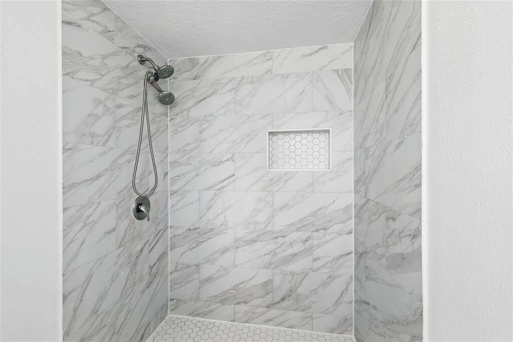The upstairs full bath features a sleek, modern-designed shower, adding a touch of sophistication to your daily routine.