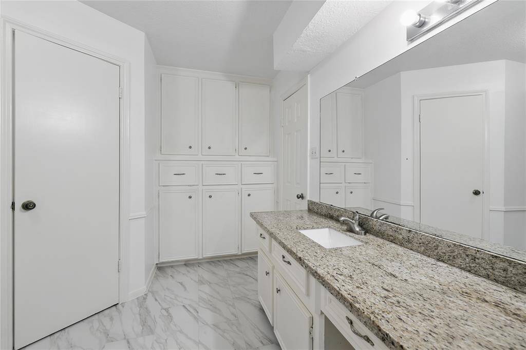 The primary bathroom features dual sinks, a sleek modern walk-in shower with a built-in bench, and a separate toilet room for added privacy.With both his and hers closets, this space offers convenience and plenty of storage, combining luxury and practicality for your daily routine.