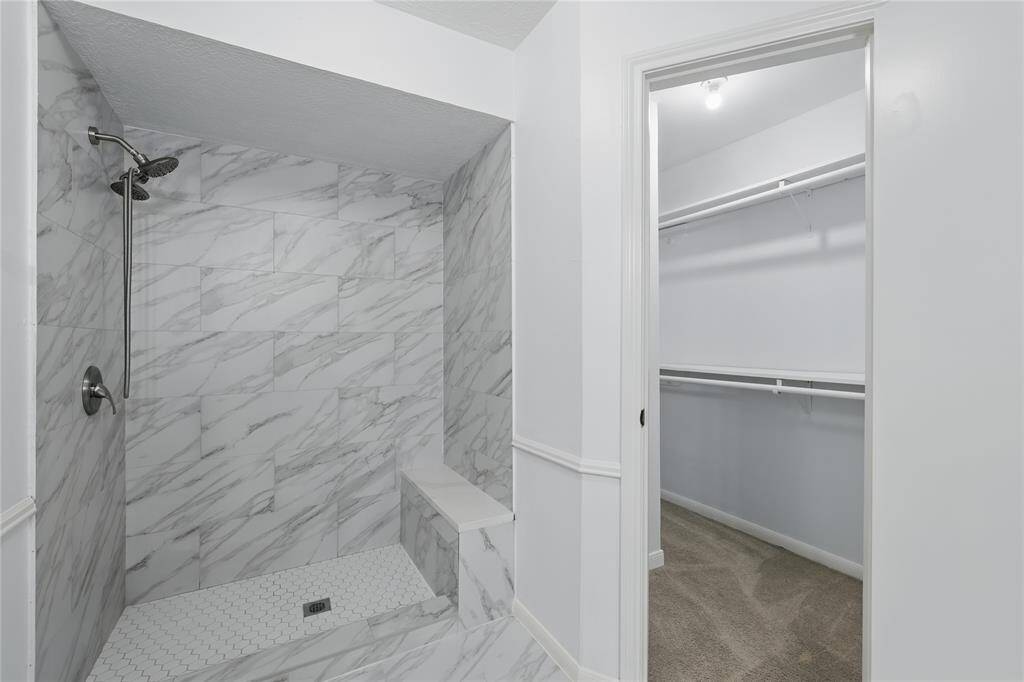The primary bathroom boasts dual sinks and a stylish walk-in shower, complete with its own bench area for added comfort.For ultimate privacy and convenience, you'll also find a separate toilet room and spacious his-and-hers closets, offering plenty of storage and organization.