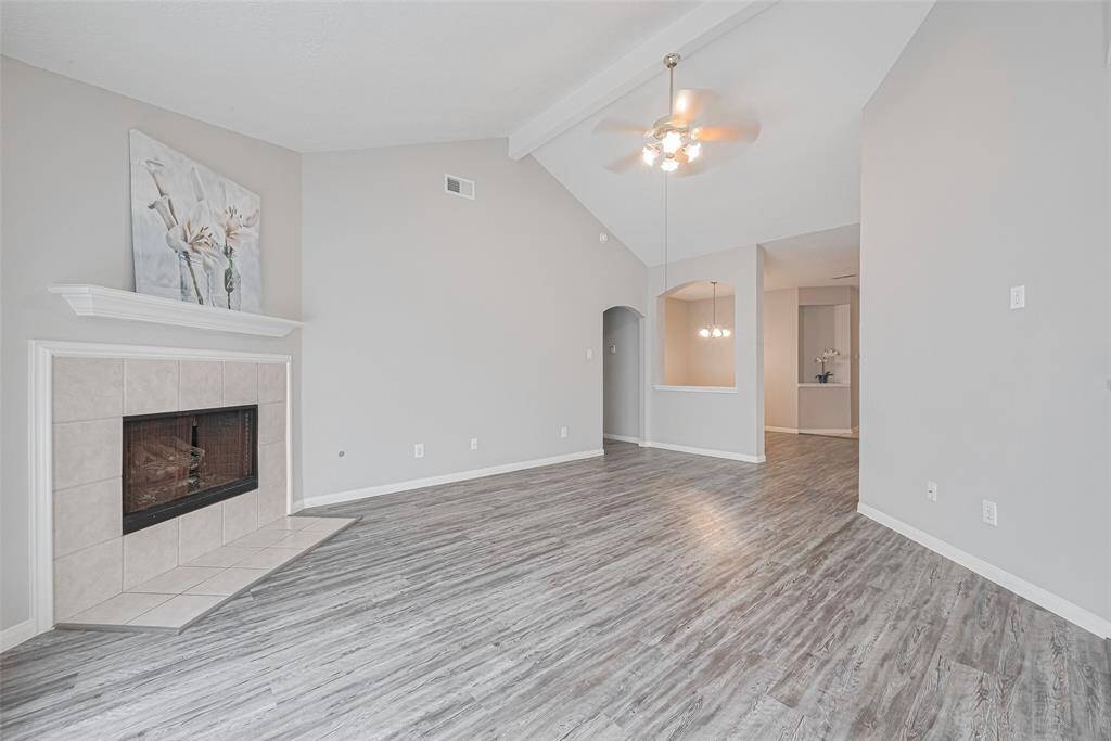 Imagine cozy evenings in the living room, featuring a charming fireplace as a focal point. The room is enhanced by a ceiling fan and ample natural light.