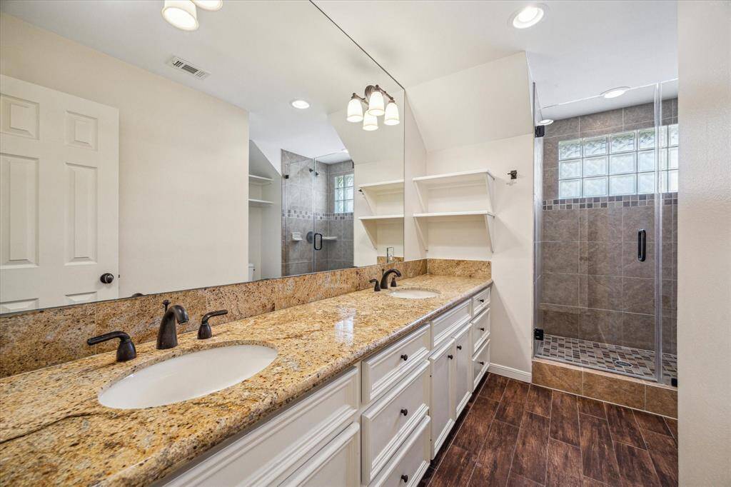Third bathroom is located upstairs and features double sinks, granite counters and shower.