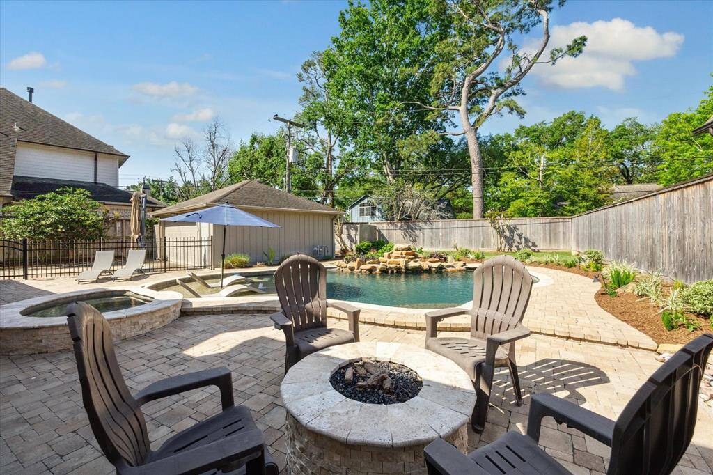 This showstopper backyard features a heated pool, hot tub, waterfall, bubblers, and a gas firepit. Plus, there's plenty of green space to run around and enjoy!