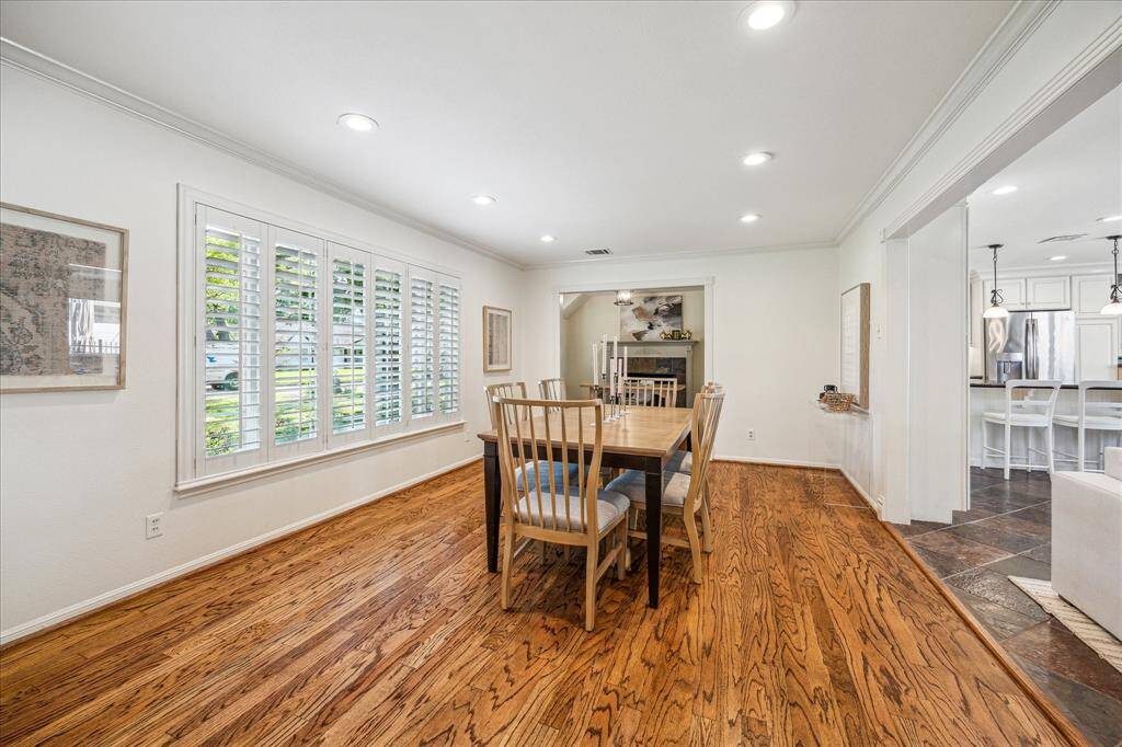 The dining room features a large window and seamlessly connects to the family room and study, all adorned with hardwood floors.