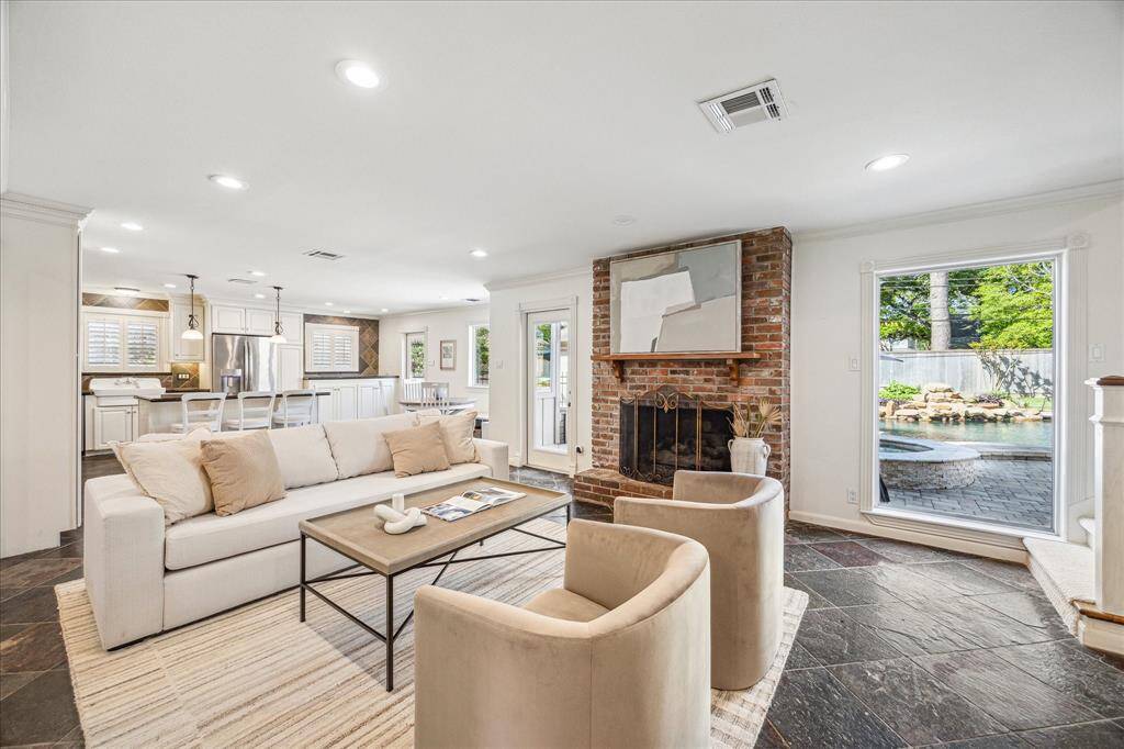 The exquisite family room boasts floor-to-ceiling windows that overlook the shimmering pool, a sophisticated gas log fireplace, and seamlessly transitions into the gourmet kitchen.