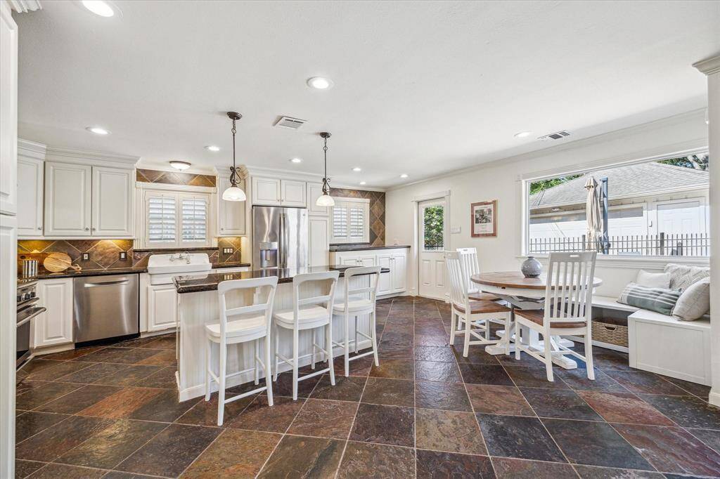 The incredible chef's kitchen boasts a grand gas range, double ovens, a spacious kitchen island, a farmhouse sink, and abundant countertop space and storage, perfect for the discerning chef.