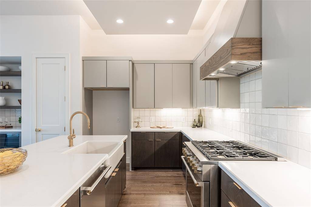 Under-cabinet lighting highlights the pristine white countertops and clean design lines.