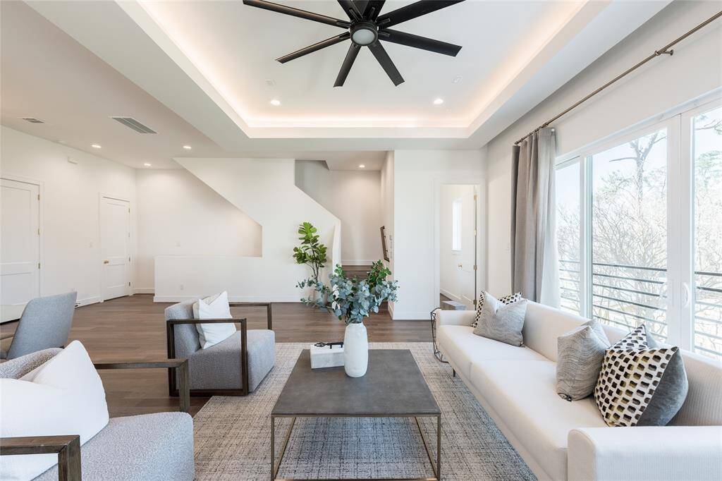 A recessed tray ceiling with LED lighting adds an elevated dimension to this sophisticated living space.